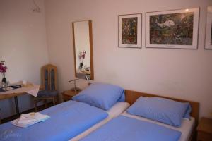 1 Schlafzimmer mit 2 Betten, einem Schreibtisch und einem Spiegel in der Unterkunft Hotel-Restaurant Denklinger-Hof in Reichshof 