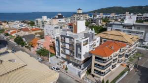 an aerial view of a city with buildings and the ocean at Nassau 203 - Excelente apartamento - Finamente mobiliado e decorado - À poucos metros da praia - (Consultar serviços de roupa de cama e banho) in Bombinhas
