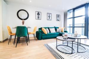 a living room with a green couch and a table at Canary Wharf-Stylish Flat-Fibre Wi-fi-10% discount in London