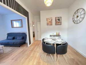 a living room with a table and a blue couch at Proche Gare- APPART Le Cocon -4 pers- Chambre séparée in Poitiers +11 photos