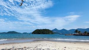 a beach with a small island in the water at Apartamentos, Praias, Piscinas, Luxo - Angra Temporada in Angra dos Reis