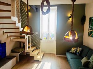 a living room with a staircase and a green couch at Vivila - Al Lucernario in Cernusco sul Naviglio