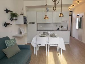 a kitchen and living room with a white table and chairs at Vivila - Al Lucernario in Cernusco sul Naviglio