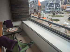 a chair in front of a window with a view of a city at Apartman Adna in Trnovo