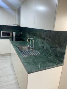 een keuken met een groen aanrecht met een wastafel bij Exclusivo Duplex CANET in Canet de Berenguer