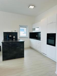 a kitchen with white cabinets and black counter tops at Künzelsau I in Künzelsau