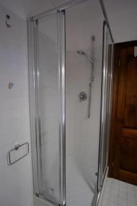 a shower with a glass door in a bathroom at Tuopina Chianti House in Lornano