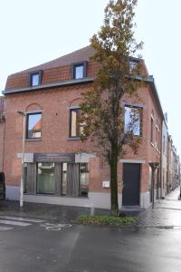 budynek z czerwonej cegły z drzewem przed nim w obiekcie Casa Maris - Het huis van de zee - Viersterrenverblijf w mieście Nieuwpoort