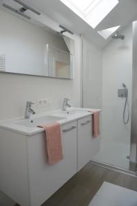 Baño blanco con 2 lavabos y espejo en Casa Maris - Het huis van de zee - Viersterrenverblijf, en Nieuwpoort