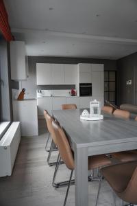 uma sala de jantar com uma mesa e cadeiras numa cozinha em Casa Maris - Het huis van de zee - Viersterrenverblijf em Nieuwpoort