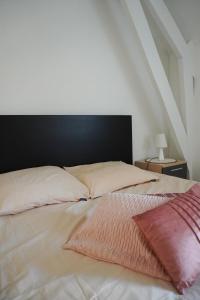 Una cama con dos almohadas encima. en Casa Maris - Het huis van de zee - Viersterrenverblijf, en Nieuwpoort