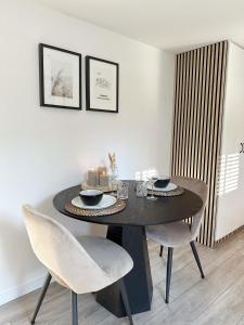 a dining room table with two chairs and a black table at Vakantiehuisje Noé in Gorinchem