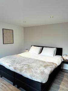 sypialnia z dużym łóżkiem z 2 białymi poduszkami w obiekcie Vakantiehuisje Noé w mieście Gorinchem
