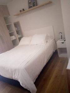 1 dormitorio con cama blanca y suelo de madera en Monoambiente en El Prado, en Cochabamba