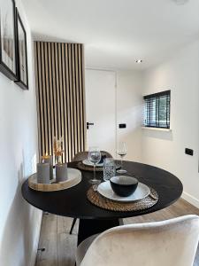 a dining room with a black table and chairs at Vakantiehuisje Noé in Gorinchem