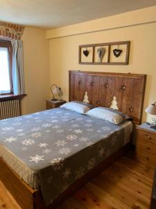 a bedroom with a large bed with a wooden headboard at Monte Emilius Alloggio ad uso turistico VDA SAINT CHRISTOPHE n 0002 in Saint-Christophe