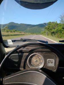 une vue sur le tableau de bord d'une voiture sur une route dans l'établissement Long Life Campeche-Pousada, à Florianópolis