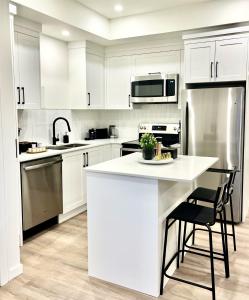 eine Küche mit weißen Schränken und einer weißen Arbeitsplatte in der Unterkunft Luxurious & Stylish 2BR P/Suite, Near Vancouver in Langley