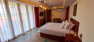 een slaapkamer met een bed met witte lakens en grote ramen bij Pink Tulip Hoi An in Hội An