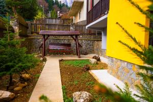 a garden with a wooden bench in a yard at Casa Valentino in Buşteni