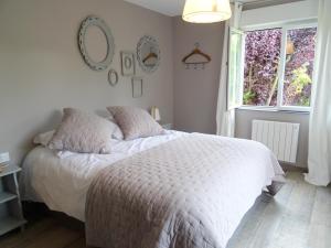 a bedroom with a bed and two mirrors on the wall at Abri Cotier in Hautot-sur-Mer