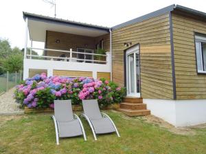 two chairs in front of a house with flowers at Abri Cotier in Hautot-sur-Mer