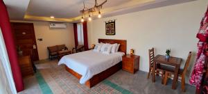 a bedroom with a bed and a table and chairs at Pink Tulip Hoi An in Hoi An