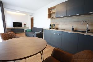 a kitchen and a living room with a table at Apartment Senec pri Aquaparku in Senec