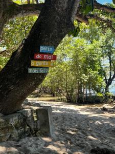 a sign hanging from a tree in a park at Pousada Maré Alta em Boipeba in Ilha de Boipeba