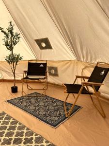 two laptops sitting in a tent with a rug at Maleka Farm: Tent Glamping North Shore Oahu in Laie