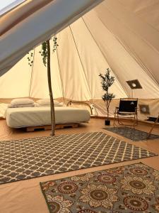 a tent with a bed and a rug in a room at Maleka Farm: Tent Glamping North Shore Oahu in Laie