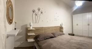 een slaapkamer met een bed en een muur met paardenbloemen bij Casa Butera Sicily in Bagheria