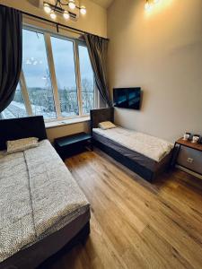 a bedroom with two beds and a large window at AJ Chocolate Vilnius in Vilnius