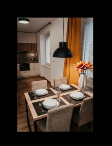 a dining room table with chairs and a vase of flowers at Old Town city center apartment 2 - private parking included in Košice