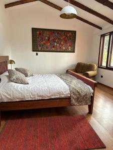 1 dormitorio con cama y alfombra roja en El Tambo Retreat, en Machachi