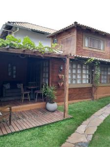 a house with a wooden deck in the yard at Casa Rústica Lisboa 100m da praia in Balneário Camboriú