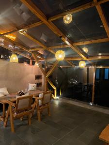 a dining room with a table and chairs and lights at Pahadi House in Nārkanda