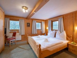 1 dormitorio con 1 cama blanca grande y ventanas en Gasthof Mamooserhof, en Penning