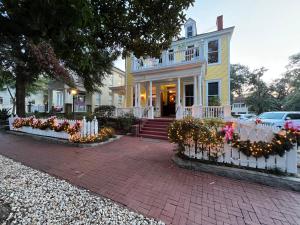 a yellow house with flowers in front of it at Azalea Inn and Villas in Savannah