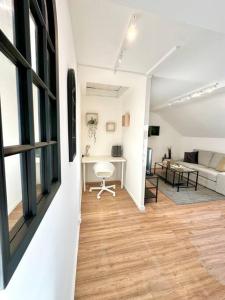 a living room with a couch and a table at Le Bois Tordu in Dijon