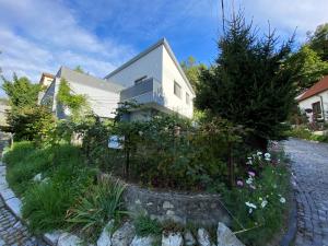 a white house with a garden in front of it at Rosemary Apartment in Bratislava