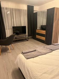um quarto de hotel com uma cama e uma televisão de ecrã plano em Апартамент за гости Генови em Vratsa