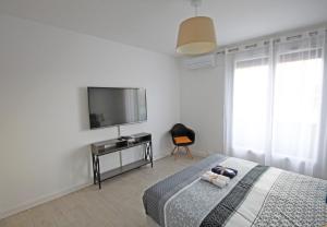 - une chambre avec un lit et une télévision murale dans l'établissement Appartement Centre Perpignan 3 pièces 70m2 Avec Climatisation, à Perpignan