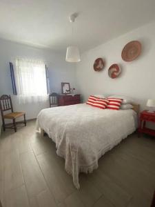 a bedroom with a bed with red and white pillows at Ferroa Guest House in Cano