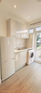 a white kitchen with a sink and a dishwasher at Hendon Garden in The Hyde in The Hyde
