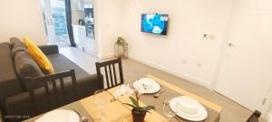 a dining room with a table and a couch at Hendon Garden in The Hyde in The Hyde