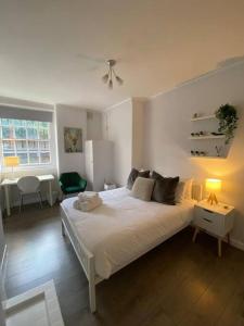 1 dormitorio con 1 cama blanca grande en una habitación en London's Charm - Best Spot in Modern 2BR, King's Cross, en Londres