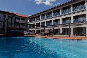 a large swimming pool in front of a building at Acres Inn Klerksdorp in Klerksdorp