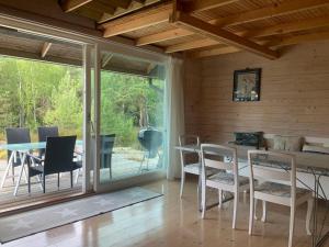 ein Esszimmer mit einem Tisch und Stühlen sowie eine Terrasse in der Unterkunft Cozy Cabin in Stockholms Archipelago in Ingmarsö