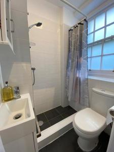 a bathroom with a toilet and a shower and a sink at London's Charm - Best Spot in Modern 2BR, King's Cross in London